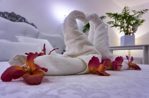 a towel animal sitting on a bed with flowers at Giada in Gussago