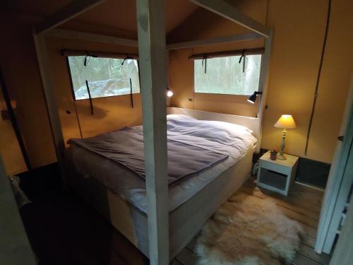a bedroom with a canopy bed with a rug at Le Refuge in Namur