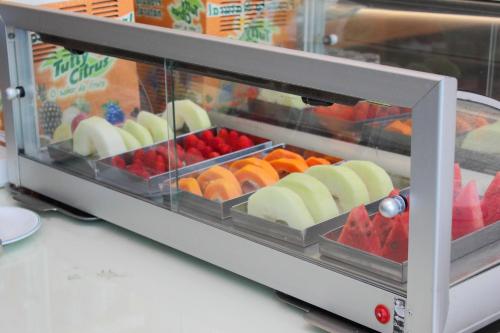 a display case filled with different types of fruit at HD Plaza Hotel in Assis