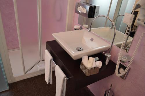 a bathroom with a sink and a mirror at Boutique Hotel La Rinascente in Locarno