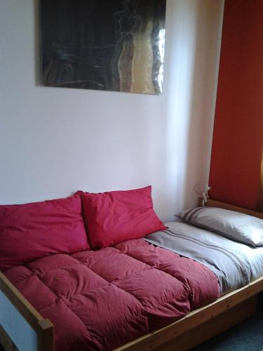 a bed with red sheets in a room at Le Magnolie B&B in Bussero