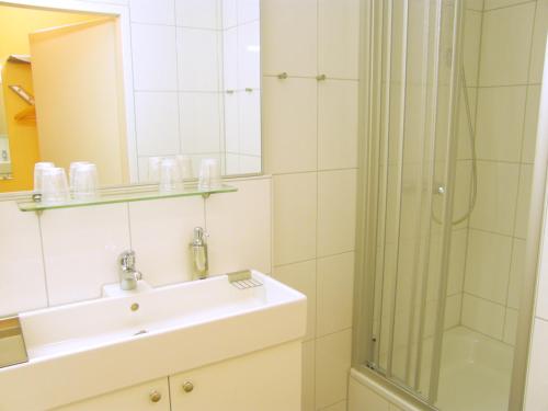 W łazience znajduje się umywalka i prysznic. w obiekcie City Guesthouse Pension Berlin w Berlinie