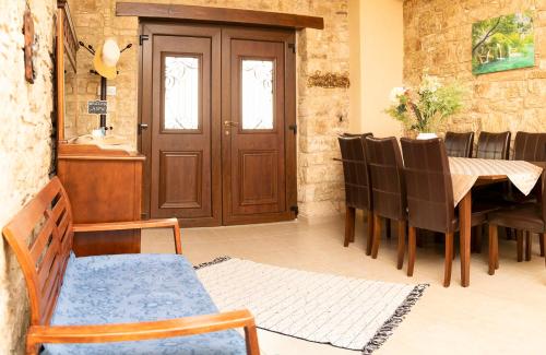a dining room with a wooden door and a table and chairs at Salamiou Stone House in Paphos City
