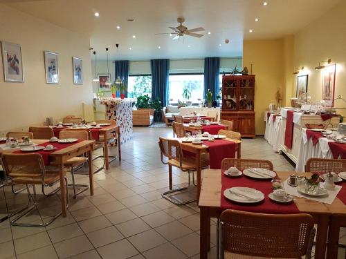 un restaurante con mesas de madera y sillas con manteles rojos en Art Hotel Köln en Colonia