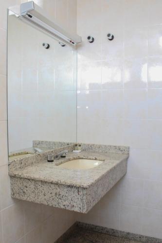 a bathroom with a sink and a mirror at HD Plaza Hotel in Assis