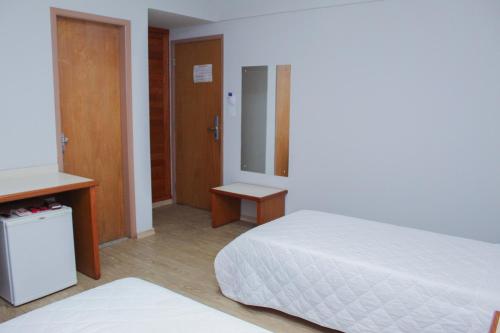 a hotel room with a bed and a mirror at HD Plaza Hotel in Assis