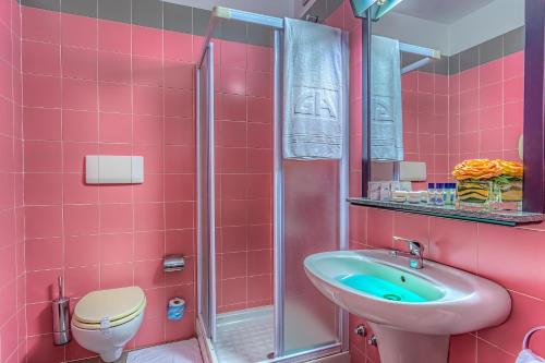 różowa łazienka z umywalką i prysznicem w obiekcie Gotha Hotel Turin Airport w mieście Ciriè