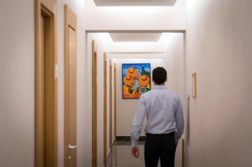 a man standing in a hallway looking at a painting at Hotel Giolli Nazionale in Rome
