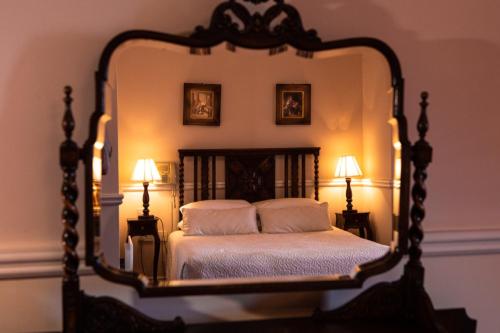 a bedroom with a large mirror above a bed at Kilcooly's Country House Hotel in Ballybunion