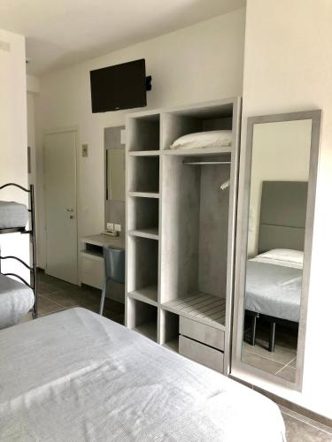 a bedroom with a bed and a tv and a mirror at Hotel Eugenio in Cesenatico