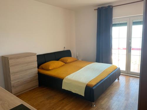 um quarto com uma cama com almofadas amarelas e uma cómoda em Villa M Studio Apartment em Ljubac