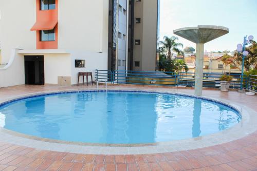 a large blue pool in the middle of a building at HD Plaza Hotel in Assis