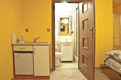 a bathroom with a toilet and a sink and a door at Willa ,, Krokus" in Ciche