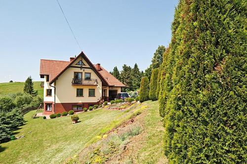 a house on a hill next to a large hedge at Willa ,, Krokus" in Ciche