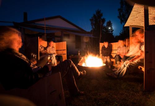a group of people sitting around a fire at night at destinature Dorf Hitzacker in Hitzacker