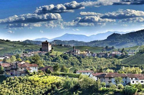 a village on a hill with mountains in the background at Casa dei Nonni #charminglanga in Grinzane Cavour