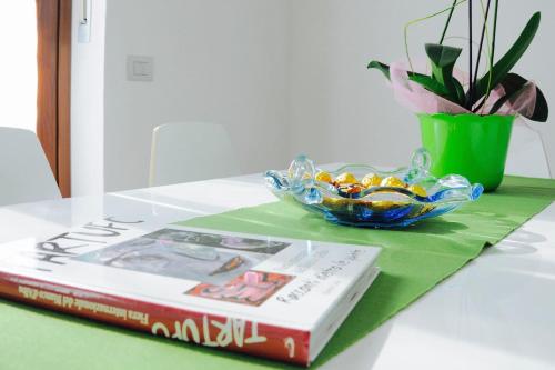 a book sitting on a table next to a bowl of candy at Casa dei Nonni #charminglanga in Grinzane Cavour