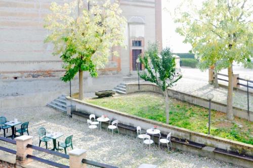 a group of white chairs and tables and trees at Casa dei Nonni #charminglanga in Grinzane Cavour
