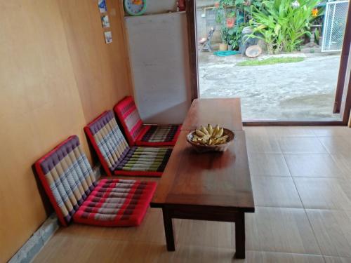a table with two chairs and a bowl of bananas on it at paibaansuan in Pai