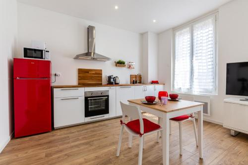 Il comprend une cuisine équipée d'un réfrigérateur rouge et d'une table avec des chaises. dans l'établissement MISIRLOU -Superbe Studio dans la Vieille Ville, à Marseille