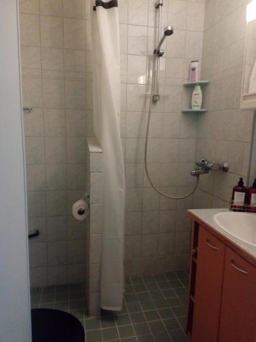 ein Badezimmer mit Dusche und weißem Duschvorhang in der Unterkunft Apartment Widbominkulma in Pori
