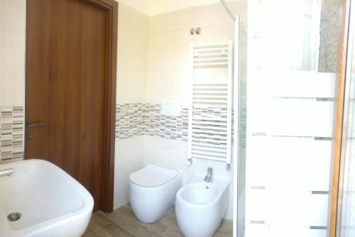 a bathroom with a tub and a toilet and a sink at Foresteria Sirio in Gorgonzola