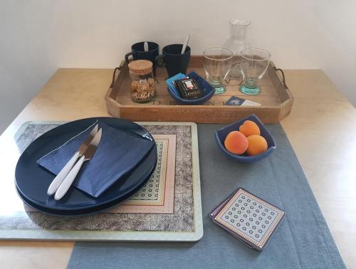 uma mesa com um prato azul e tigelas de laranjas em Chatimbarbe em Yssingeaux