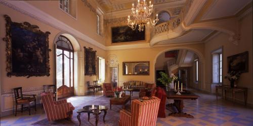 a living room with a chandelier and a table and chairs at Sina Villa Matilde in Romano Canavese