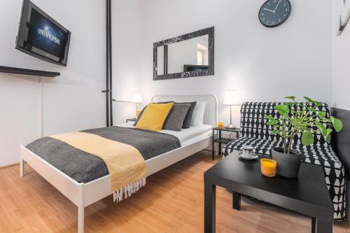 - une chambre avec un lit, une table et un canapé dans l'établissement Apartments Wilcza 55 by Renters, à Varsovie