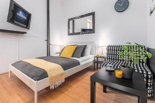 sypialnia z łóżkiem, stołem i kanapą w obiekcie Apartments Wilcza 55 by Noclegi Renters w Warszawie