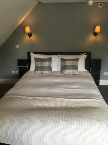 a bedroom with a large bed with two pillows at The Row Barge Henley in Henley on Thames