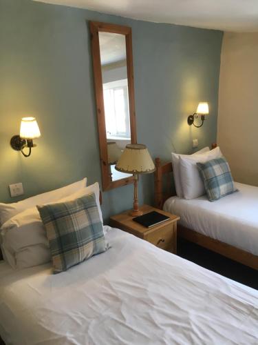um quarto de hotel com duas camas e um espelho em The Row Barge Henley em Henley on Thames