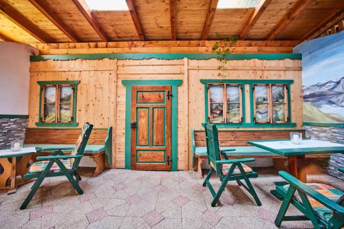 a cabin with tables and chairs and a door at Hotel Brennerspitz in Neustift im Stubaital