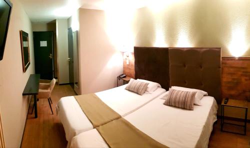 a bedroom with a large bed with white sheets and pillows at Euro Hôtel Paris Créteil in Créteil