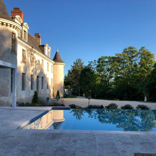 un domaine avec une piscine en face d'un bâtiment dans l'établissement Domaine Plessis Gallu - vacation cottage rental, à Azay-le-Rideau