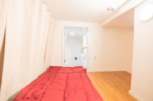 a bed in a room with a red blanket at Huayuanhouse HQ in hongdae in Seoul
