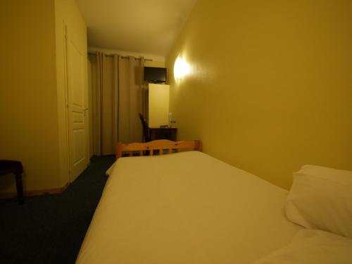 a hotel room with two beds and a door at Le Relais de Gascogne in Auch