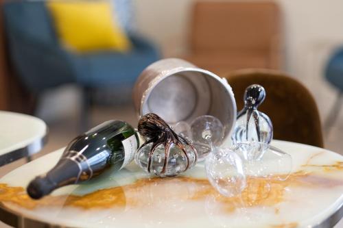 a bottle of wine on a plate with wine glasses at Hôtel de France, un hôtel AMMI in Nice