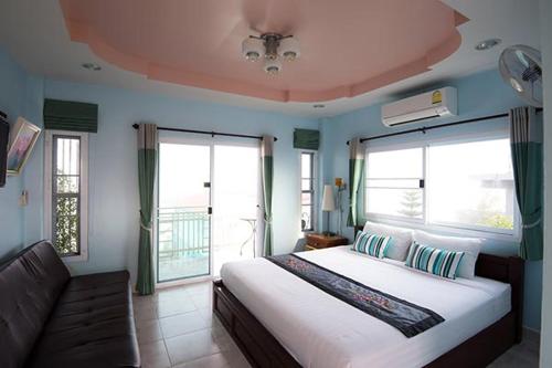 1 dormitorio con cama, sofá y ventanas en Hotel Viewpoint Khao Koh en Khao Kho
