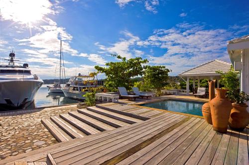 a luxury house with a swimming pool and a boat at Barefoot Cay Resort in Roatan