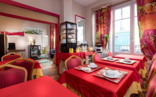 une salle à manger avec deux tables et un tissu de table rouge dans l'établissement Hôtel Montsouris Orléans, à Paris