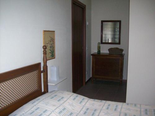 a bedroom with a bed and a dresser and a mirror at La Bottega Del Falegname in Vanzaghello