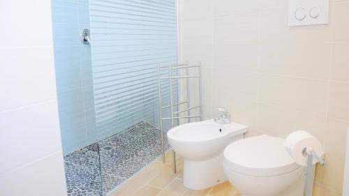 a bathroom with a toilet and a glass shower at Casa dei Nonni #charminglanga in Grinzane Cavour