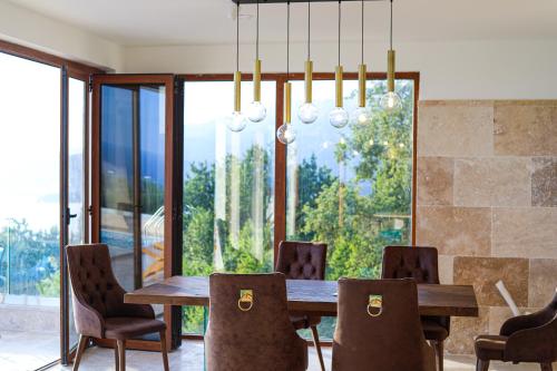 a dining room with a wooden table and chairs at Villa Horus in Sveti Stefan