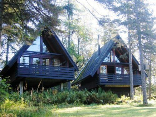 two blue homes in the woods with trees at Lofoten Feriesenter in Svolvær