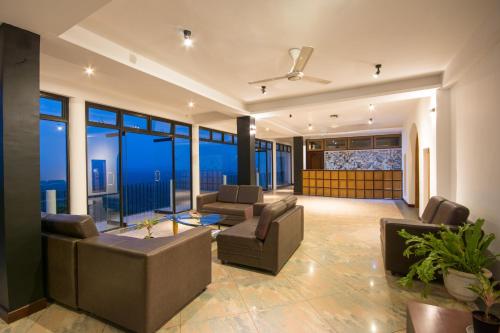 a living room filled with furniture and a large window at Ceyloni Panorama Resort in Kandy