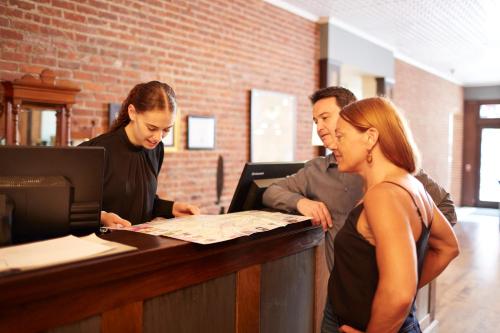 three people standing at a counter looking at a map at Hotel on North in Pittsfield