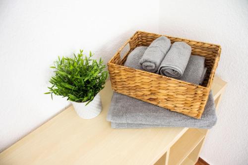 ein Korb auf einem Tisch mit Handtüchern und einer Pflanze in der Unterkunft Gemütliches Apartment mit Fernblick auf die Stadt! in Trier