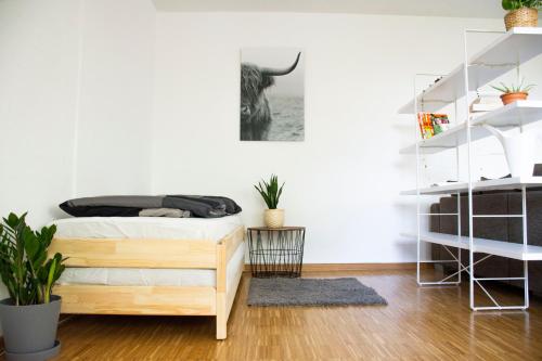 Schlafzimmer mit einem Bett und weißen Wänden in der Unterkunft Gemütliches Apartment mit Fernblick auf die Stadt! in Trier