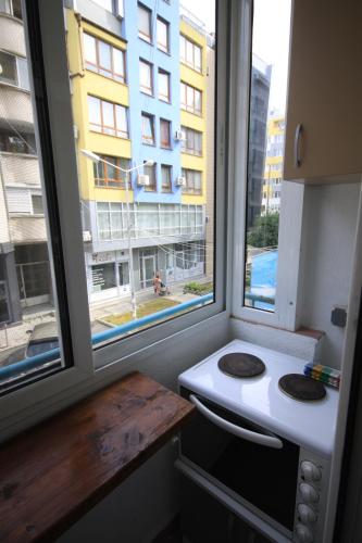 a kitchen with a window with a stove and a building at Apartments near to Burgas Free University in Burgas